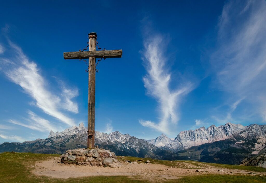 Cross in the mountains, sky with clouds in the backgroun